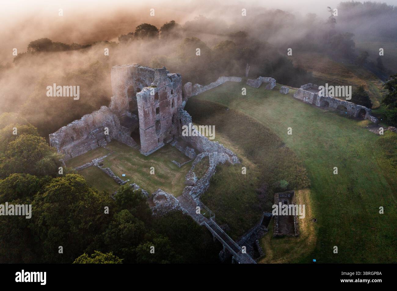 Castello di Norham uno dei più importanti castelli di confine nella nebbia estiva sul fiume Tweed Foto Stock