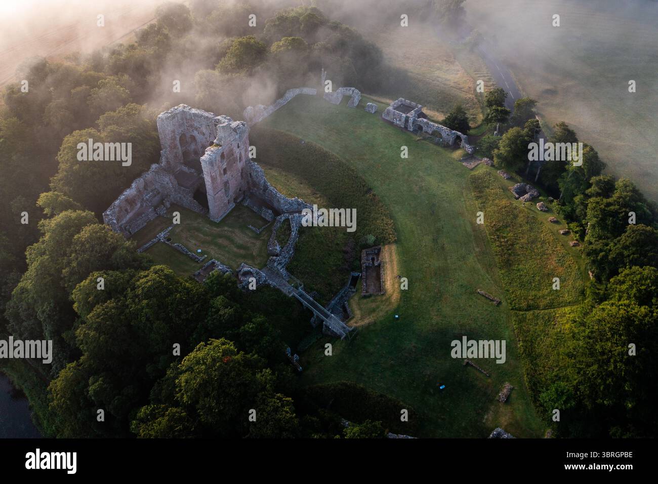 Castello di Norham uno dei più importanti castelli di confine nella nebbia estiva sul fiume Tweed Foto Stock