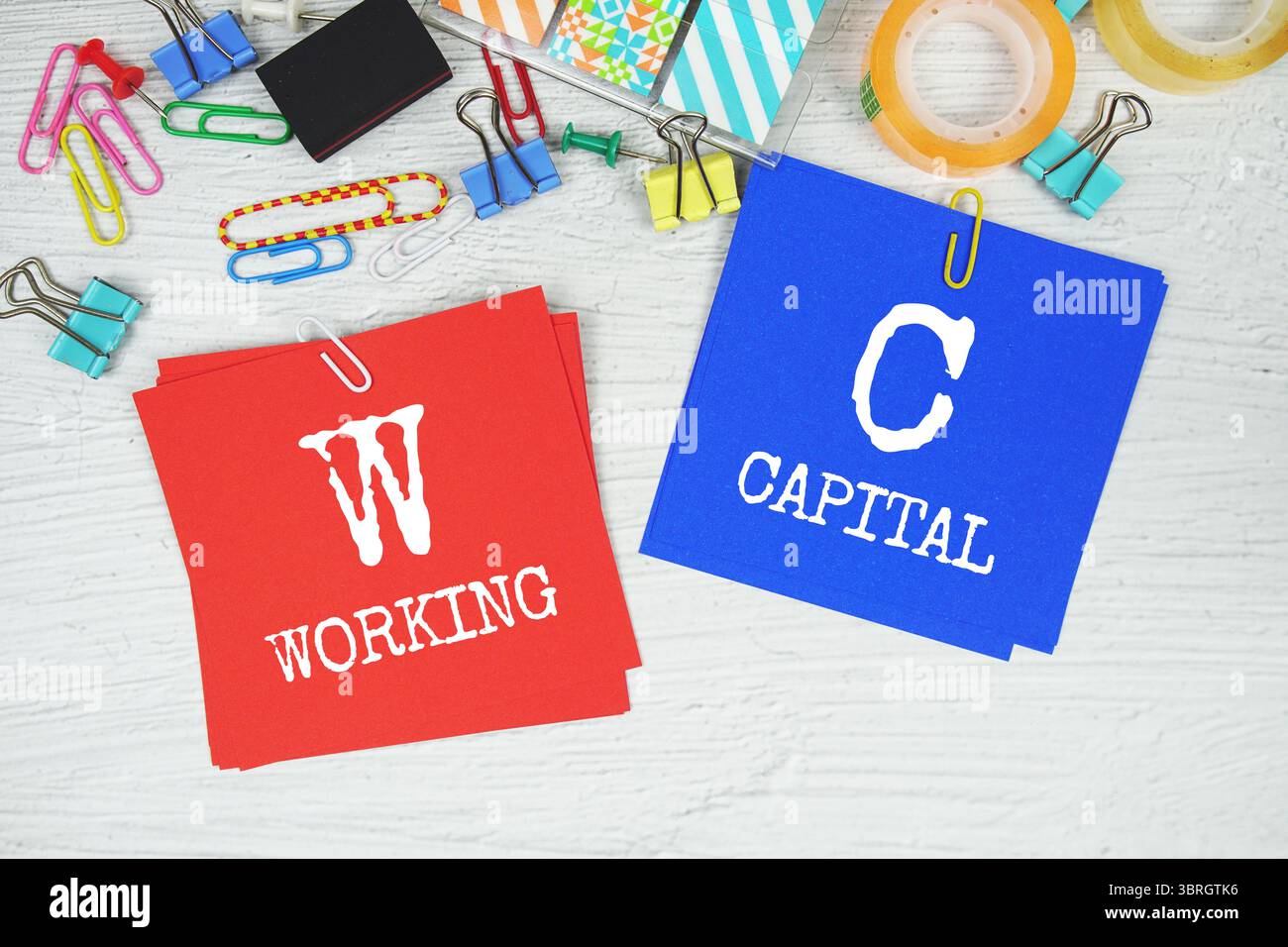 WC - testo Working Capital su stick note con cancelleria su sfondo in cemento Foto Stock