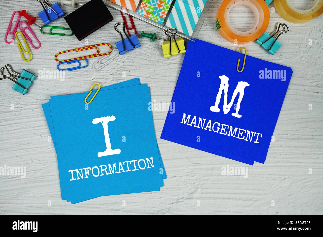 IM - testo sulla gestione delle informazioni su stick note con cancelleria su sfondo concreto Foto Stock