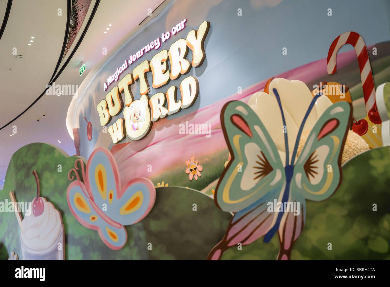 Logo di Buttery World al Siam Paragon, dove i fan di Butterbear, la mascotte virale tailandese, esplorano lo spazio a tema che unisce dessert, branding e marketing basato sui personaggi. Butterbear mania prende il controllo del Siam Paragon a Bangkok mentre i fan si riuniscono intorno alla mascotte virale thailandese trasformata in idol Internet durante un'apparizione pubblica alla sua pasticceria. Conosciuta come "Nong Noey", si è evoluta da mascotte di marca a icona della cultura pop, con copertine di danza, video di reazione e clip musicali. Una volta un successo tra i turisti cinesi, Butterbear ora affascina i fan di tutto il mondo. Foto Stock