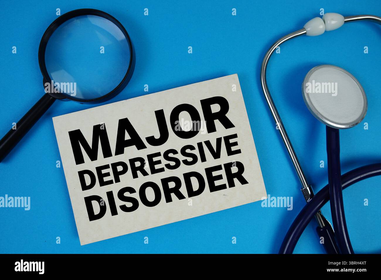 Testo per disturbo depressivo maggiore con stetoscopio e lente di ingrandimento su sfondo blu Foto Stock
