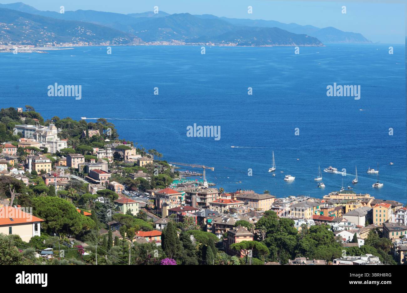 Camogli, Italia - 11 luglio 2025. Yacht, barche nella baia della Liguria. Mare e turismo in Italia. Edifici tradizionali. Sfondo per la progettazione. Foto Stock