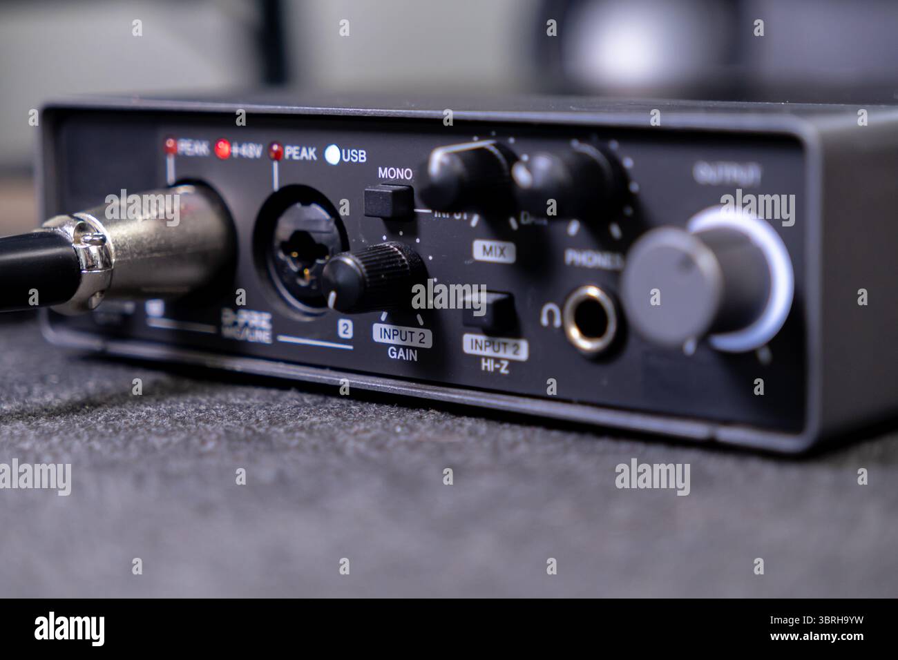 Interfaccia audio compatta con ingresso XLR, jack per cuffie, comandi di guadagno e mix, ideale per la registrazione domestica e la produzione audio Foto Stock