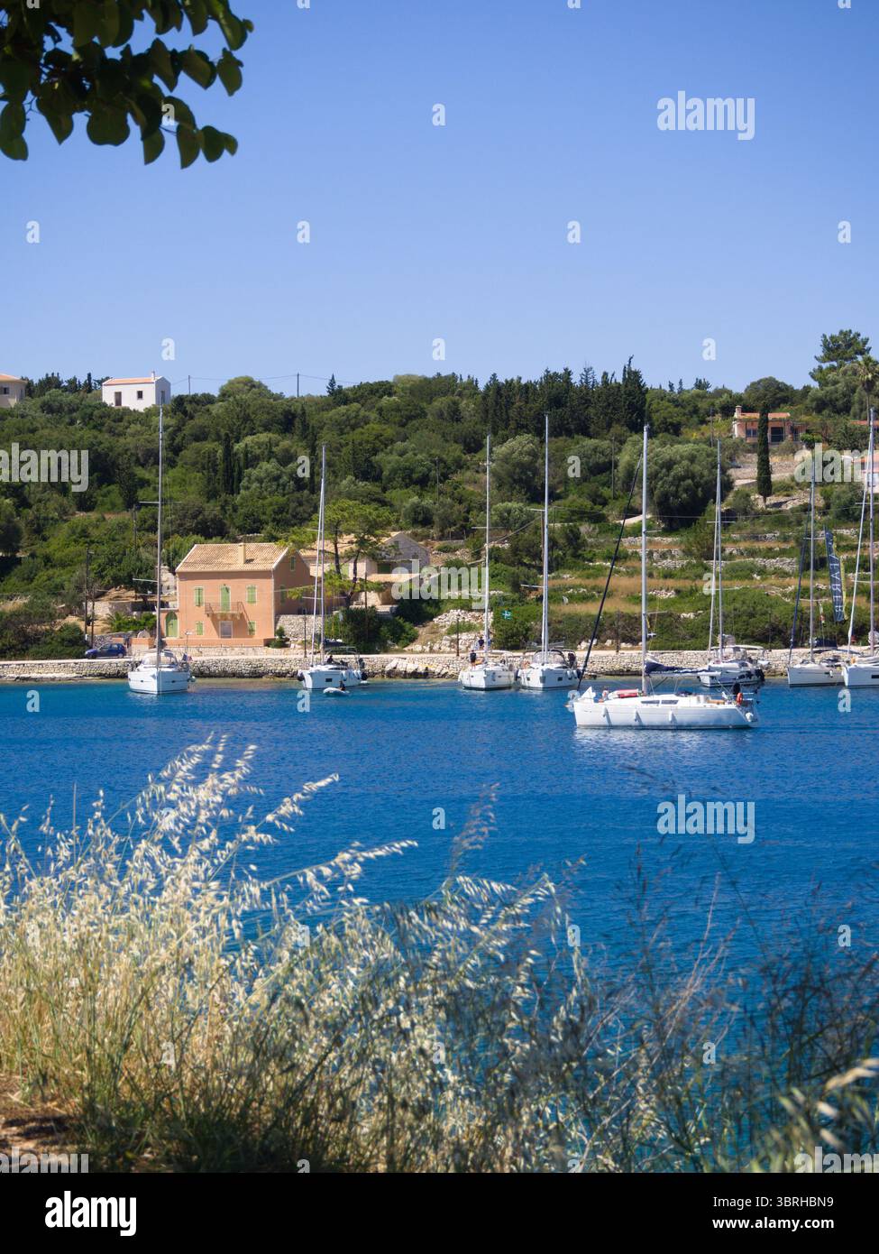 Vista sulla costa dal prato secco di Cefalonia con verdi colline e remote case di villaggio sul Mar Mediterraneo. Foto Stock