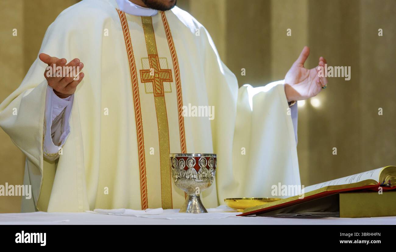Santa comunione su tavola di legno in calice di chiesa con vino rosso, pane, preghiera per il vino Foto Stock