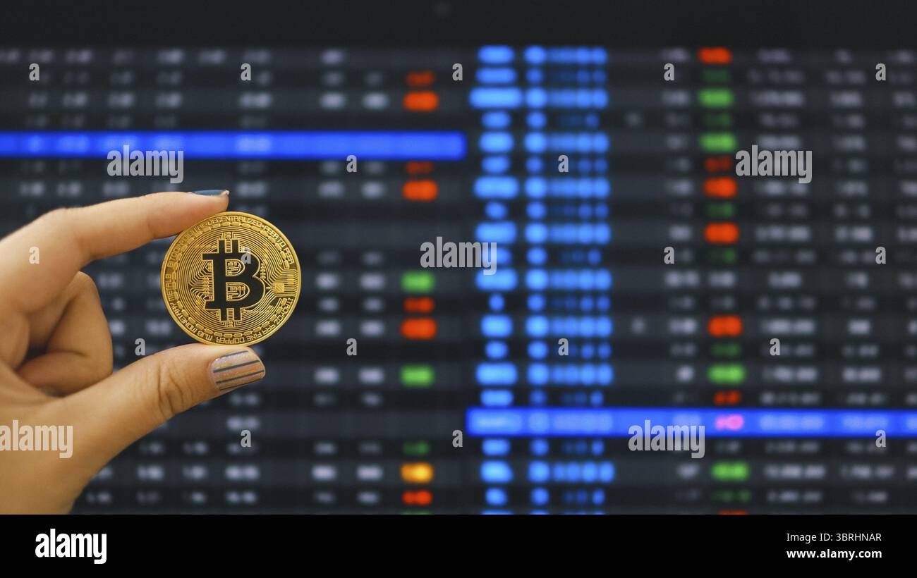 Simbolo di criptovaluta bitcoin. Oro moneta digitale che investe in risorse virtuali. Hand Hold Golden bitcoin tendenza del mercato degli investimenti finanziario Foto Stock
