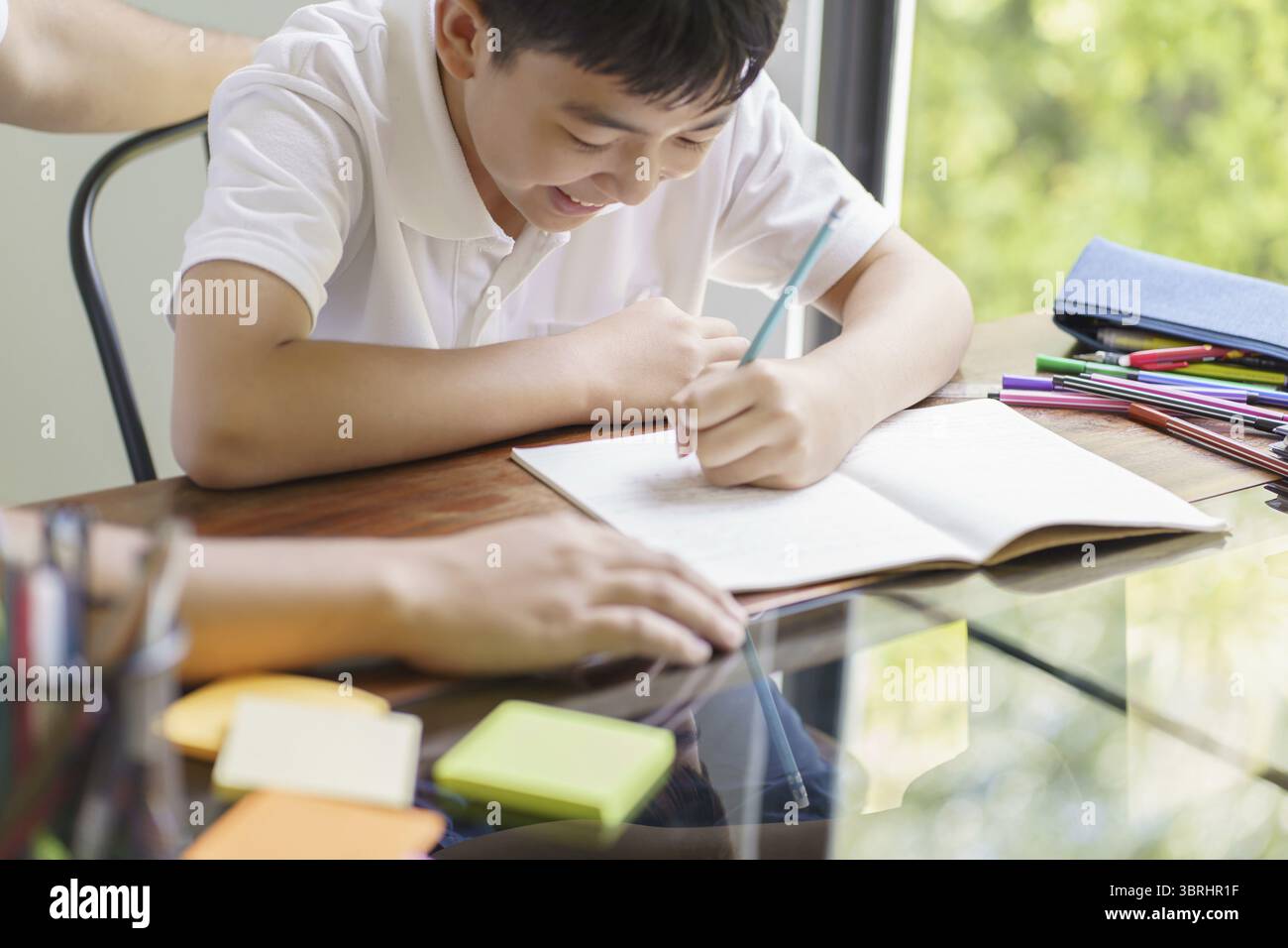 Il padre asiatico aiuta il figlio a fare i compiti per la scuola. i bambini studiano insieme concetto di scuola a casa ricevendo l'aiuto del padre per i compiti Foto Stock