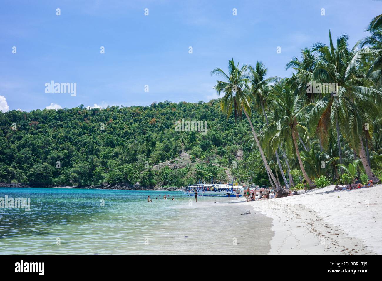 Una vista panoramica sulla costa di Palawan, Filippine, una tranquilla insenatura rocciosa con acque cristalline e poco profonde che si infrangono sulla riva. La vista naturale, fuori dalla griglia Foto Stock