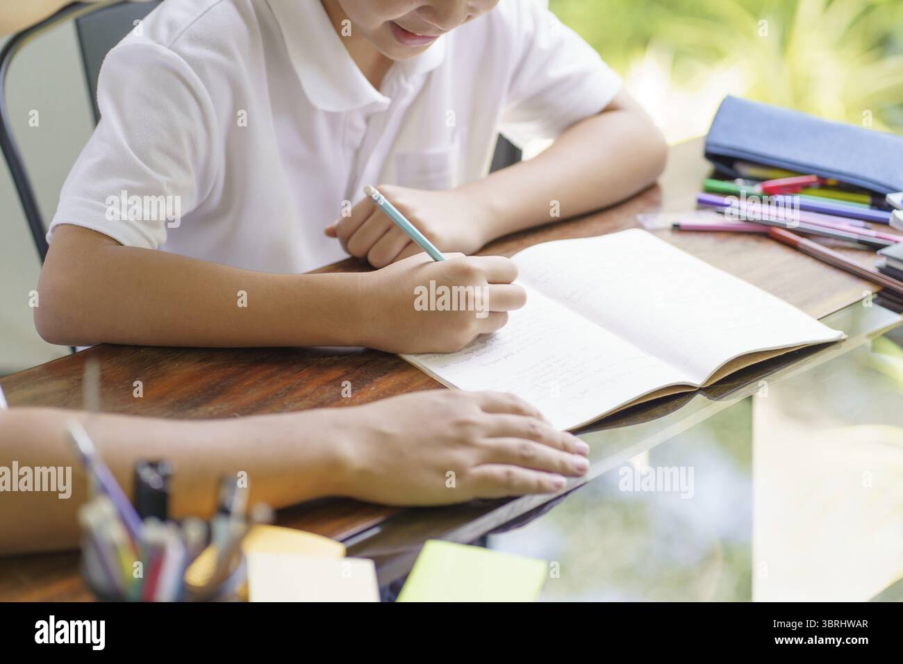 Il padre asiatico aiuta il figlio a fare i compiti per la scuola. i bambini studiano insieme concetto di scuola a casa ricevendo l'aiuto del padre per i compiti Foto Stock