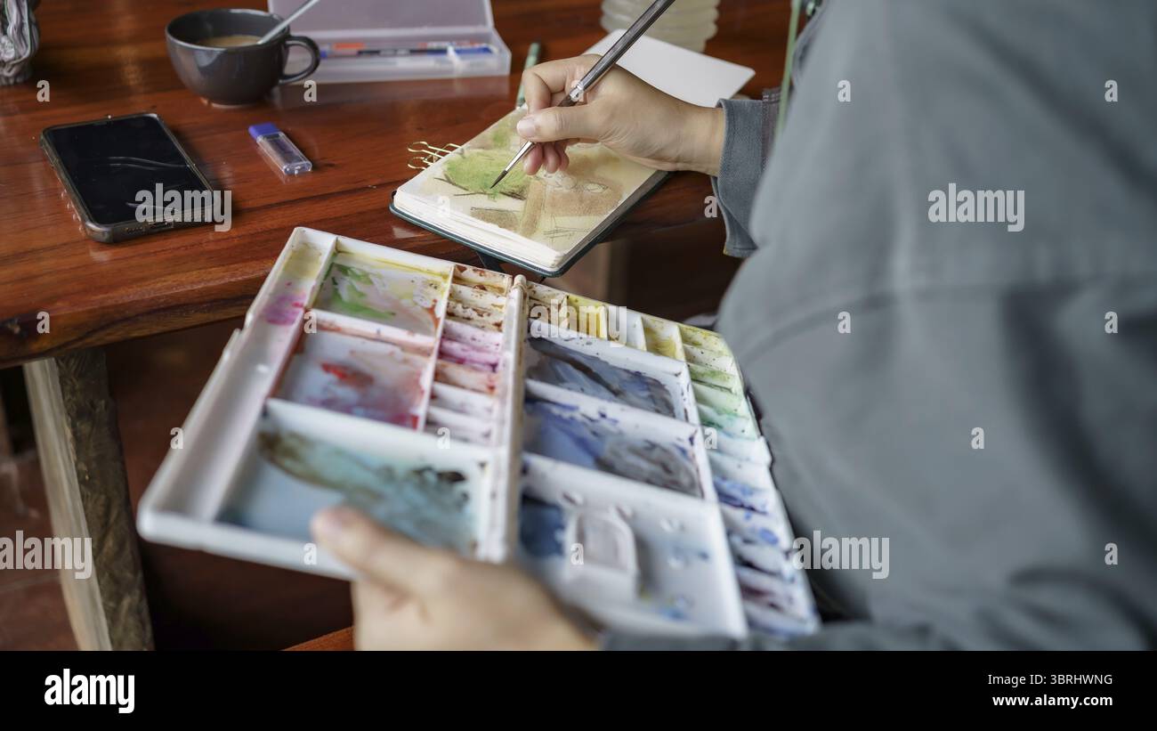 Studente in lezioni presso lo studio d'arte. Con la mano, il pennello dell'artista mescola pittura a olio di colori sulla creatività artistica della tavolozza e il concetto di persone Foto Stock