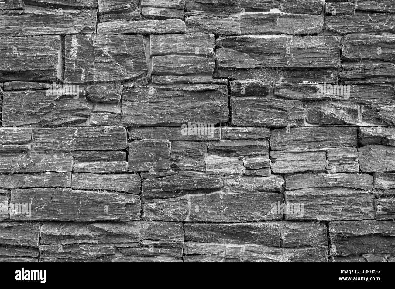 Primo piano di una parete in ardesia grigia realizzata a mano, adatta come sfondo o come sfondo Foto Stock