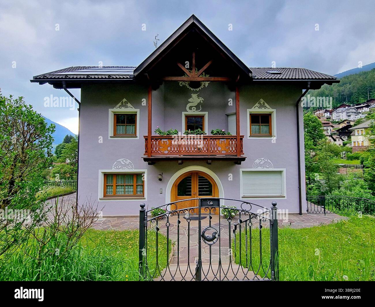 Vista di un accogliente cottage con balcone in legno e immagini di creature mitiche in alto Adige, Italia Foto Stock