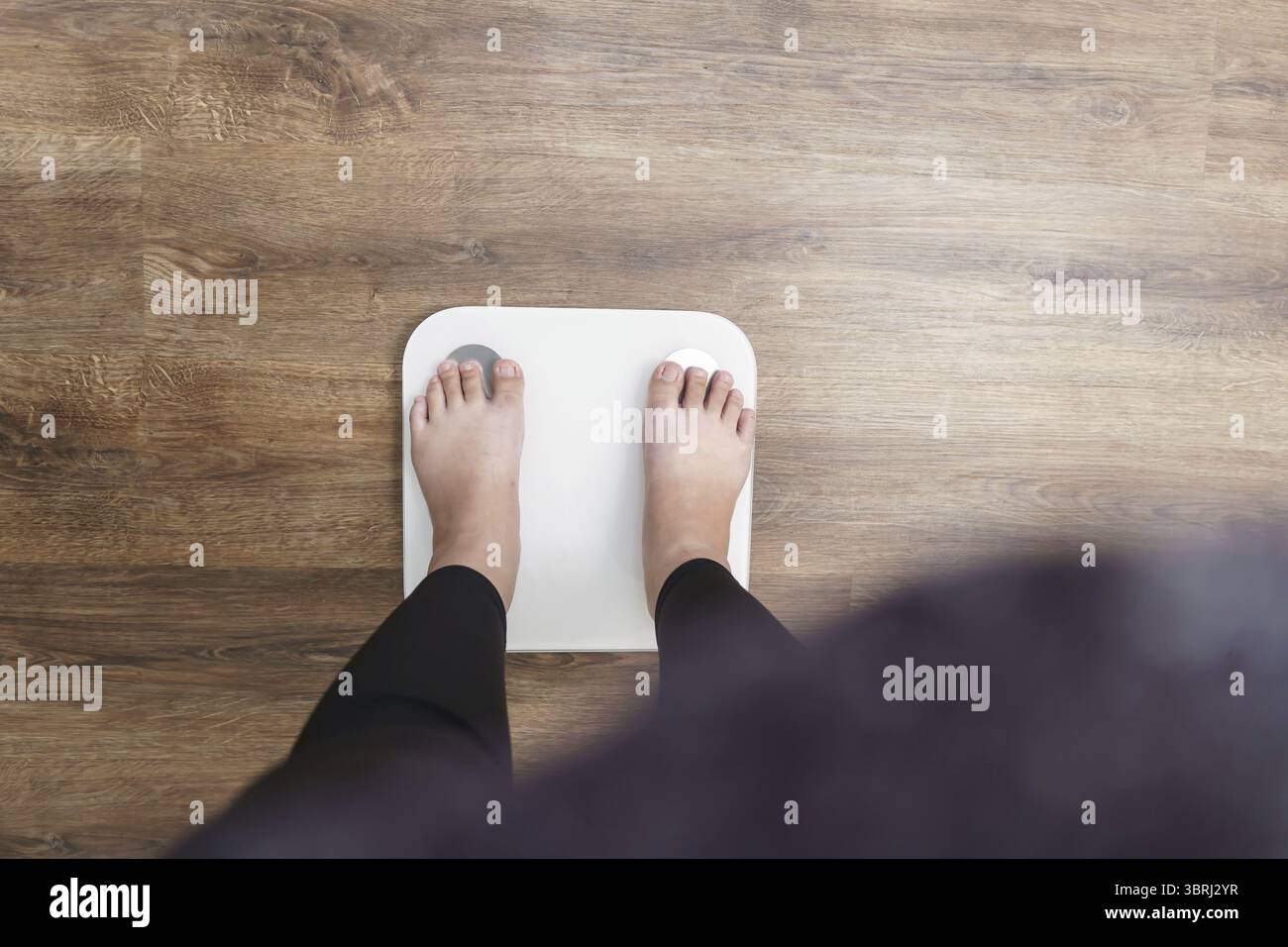 Dieta grassa e piedini graduati posizionati su bilance elettroniche per il controllo del peso. Strumento di misurazione in chilogrammi per il controllo della dieta Foto Stock