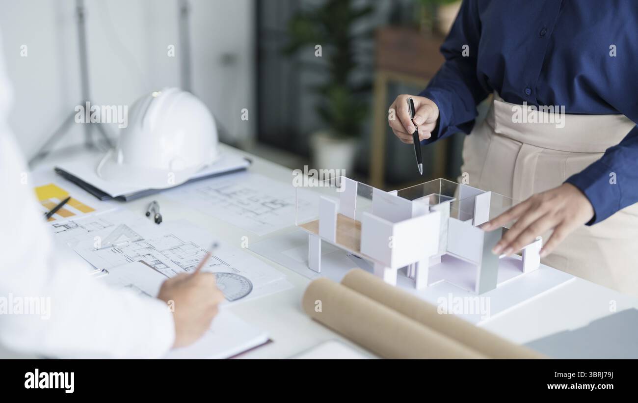 Modello di casa su Buleprint costruzione disegno e disegno attrezzature stazionario architetto che analizza casa modello casa moderna in mano architetto Design C. Foto Stock