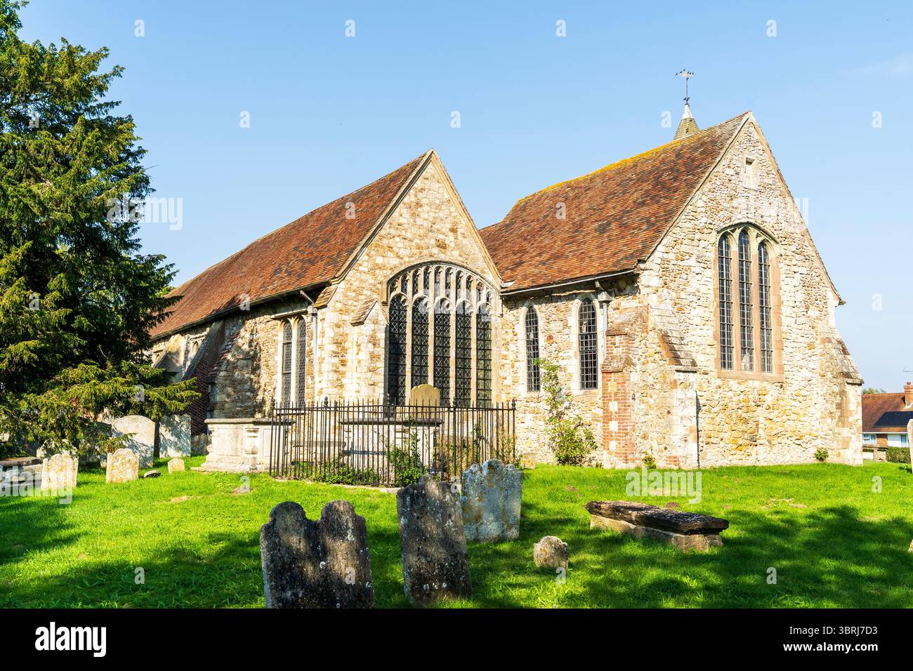 La chiesa di Sant'Agostino a Brookland, sulla Romney Marsh, risalente alla metà del XIII secolo. Esterno della cappella e delle finestre e del chanel. Lapidi di fronte. Foto Stock