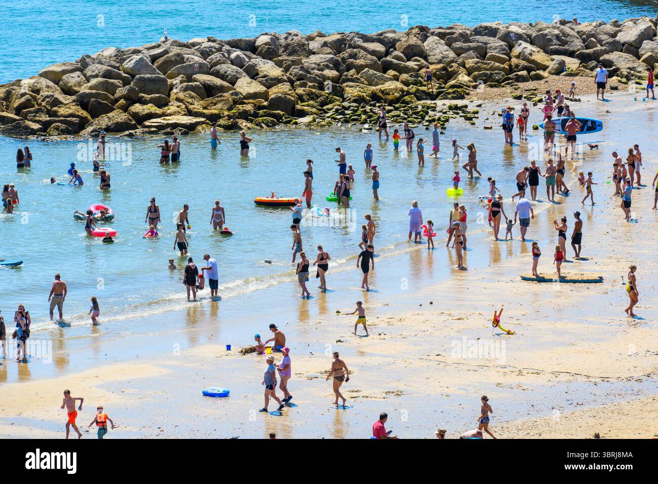 Lyme Regis, Dorset, Regno Unito. 13 luglio 2025. Meteo nel Regno Unito: I visitatori e la gente del posto si affollavano sulla spiaggia affollata della località balneare di Lyme Regis per godersi il caldo sole. Gli amanti del sole si sono crogiolati sotto il sole bollente sotto cieli azzurri senza nuvole, mentre le temperature salivano di nuovo a 30° celsius mentre l'ondata di calore continua. Crediti: Celia McMahon/Alamy Live News Foto Stock