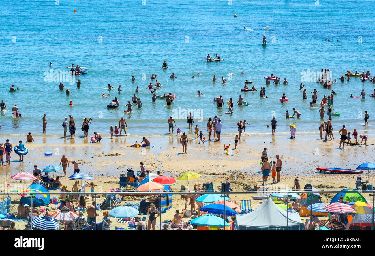 Lyme Regis, Dorset, Regno Unito. 13 luglio 2025. Meteo nel Regno Unito: I visitatori e la gente del posto si affollavano sulla spiaggia affollata della località balneare di Lyme Regis per godersi il caldo sole. Gli amanti del sole si sono crogiolati sotto il sole bollente sotto cieli azzurri senza nuvole, mentre le temperature salivano di nuovo a 30° celsius mentre l'ondata di calore continua. Crediti: Celia McMahon/Alamy Live News Foto Stock
