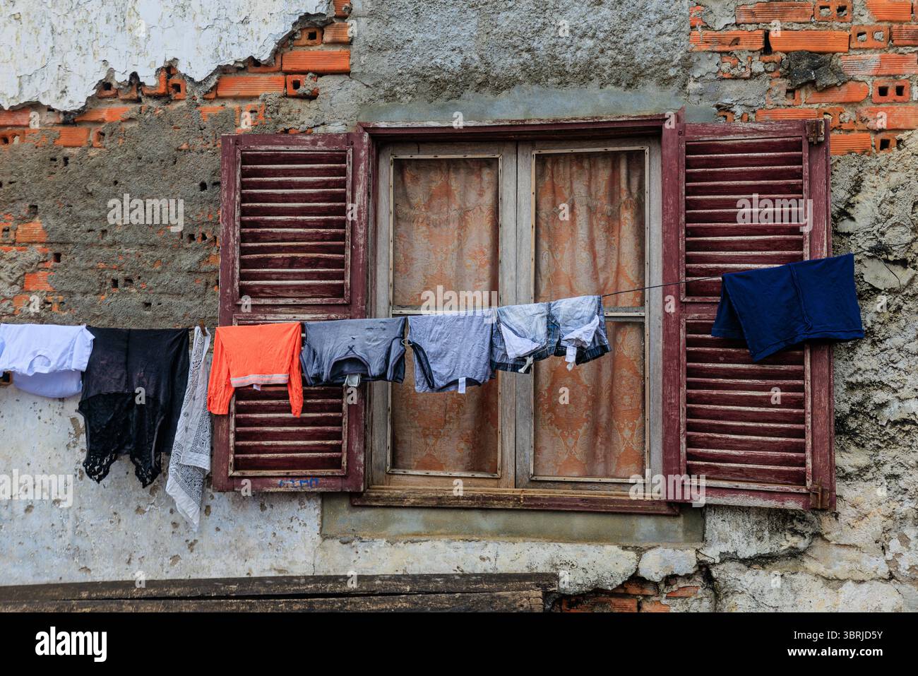 linee colorate di lavaggi pendono davanti alle finestre in legno dei magazzini abbandonati di roca agua ize e ora ospitano gli abitanti del villaggio Foto Stock