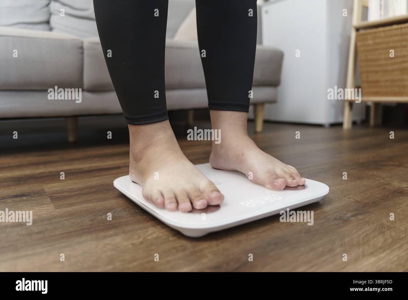 Dieta grassa e piedini graduati posizionati su bilance elettroniche per il controllo del peso. Strumento di misurazione in chilogrammi per il controllo della dieta Foto Stock