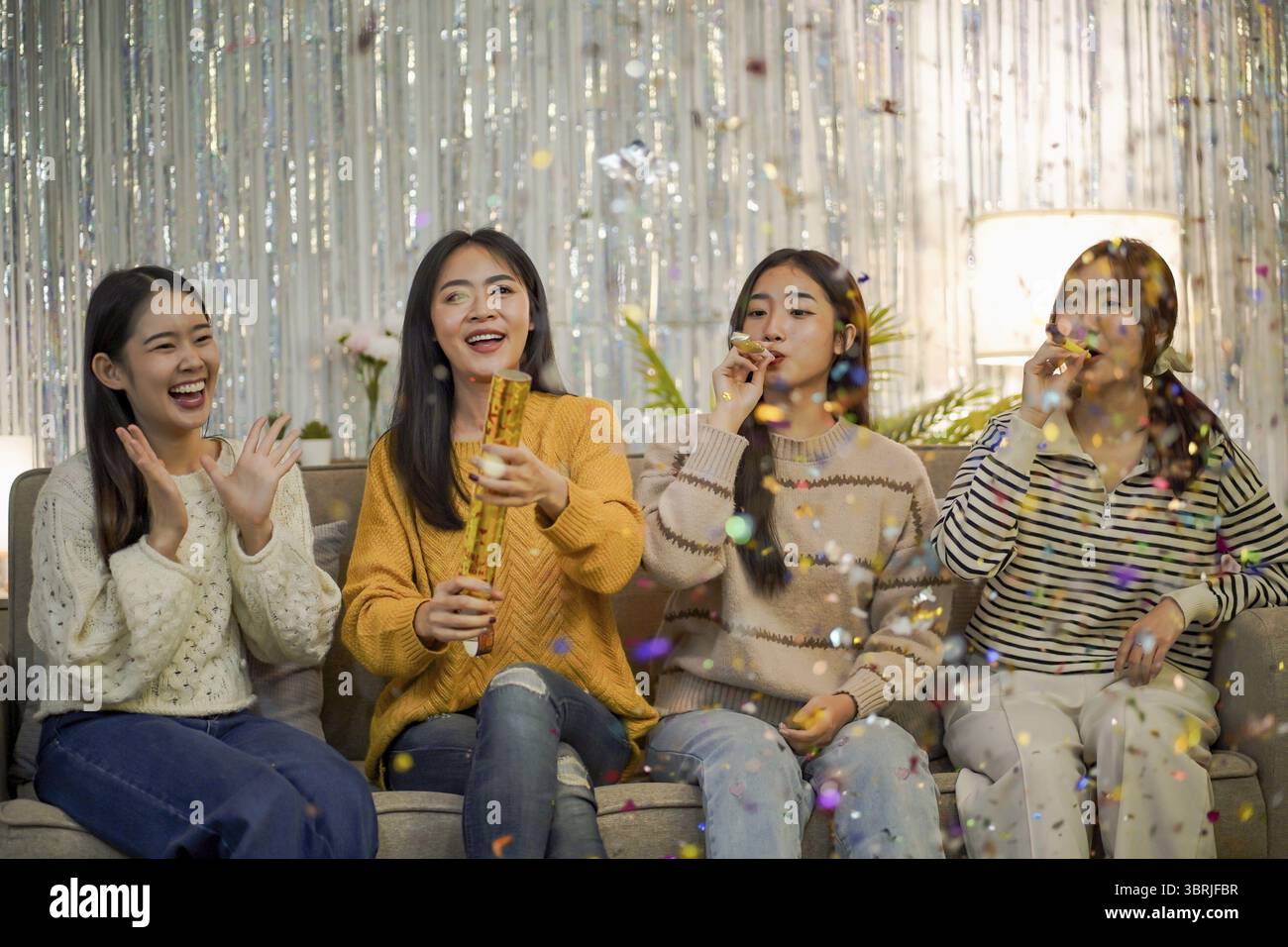 Amici allegri che si divertono con la festa di compleanno a casa. Amici asiatici che festeggiano la festa di Natale o di Capodanno Foto Stock