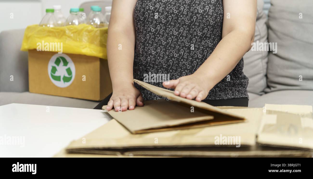 Casa riciclare il concetto di eco zero rifiuti donna che utilizza una scatola di carta riciclabile. Scatola di cartone marrone impilabile confezione ecologica realizzata in materia prima riciclabile Foto Stock Casa riciclare il concetto di eco zero rifiuti donna che utilizza una scatola di carta riciclabile. Scatola di cartone marrone impilabile confezione ecologica realizzata in materia prima riciclabile Foto Stock