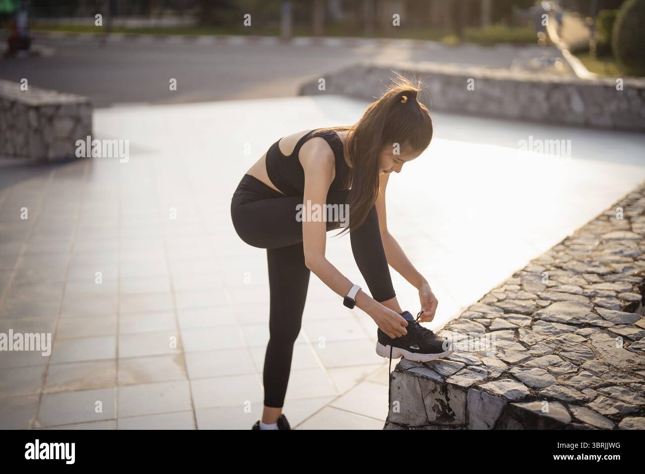 Attiva donna asiatica sana legando scarpe da corsa, jogging runner Road all'alba jogging femminile fitness e allenamento benessere salute e benessere c Foto Stock