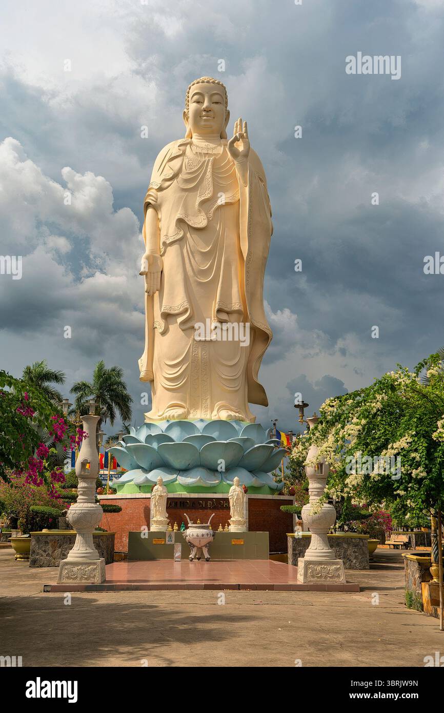 La statua del Buddha di Amitabha alta 18 metri è collocata su un piedistallo di loto nel parco Vinh Trang di fronte alla Pagoda di Vinh Trang nella città di My Tho Foto Stock