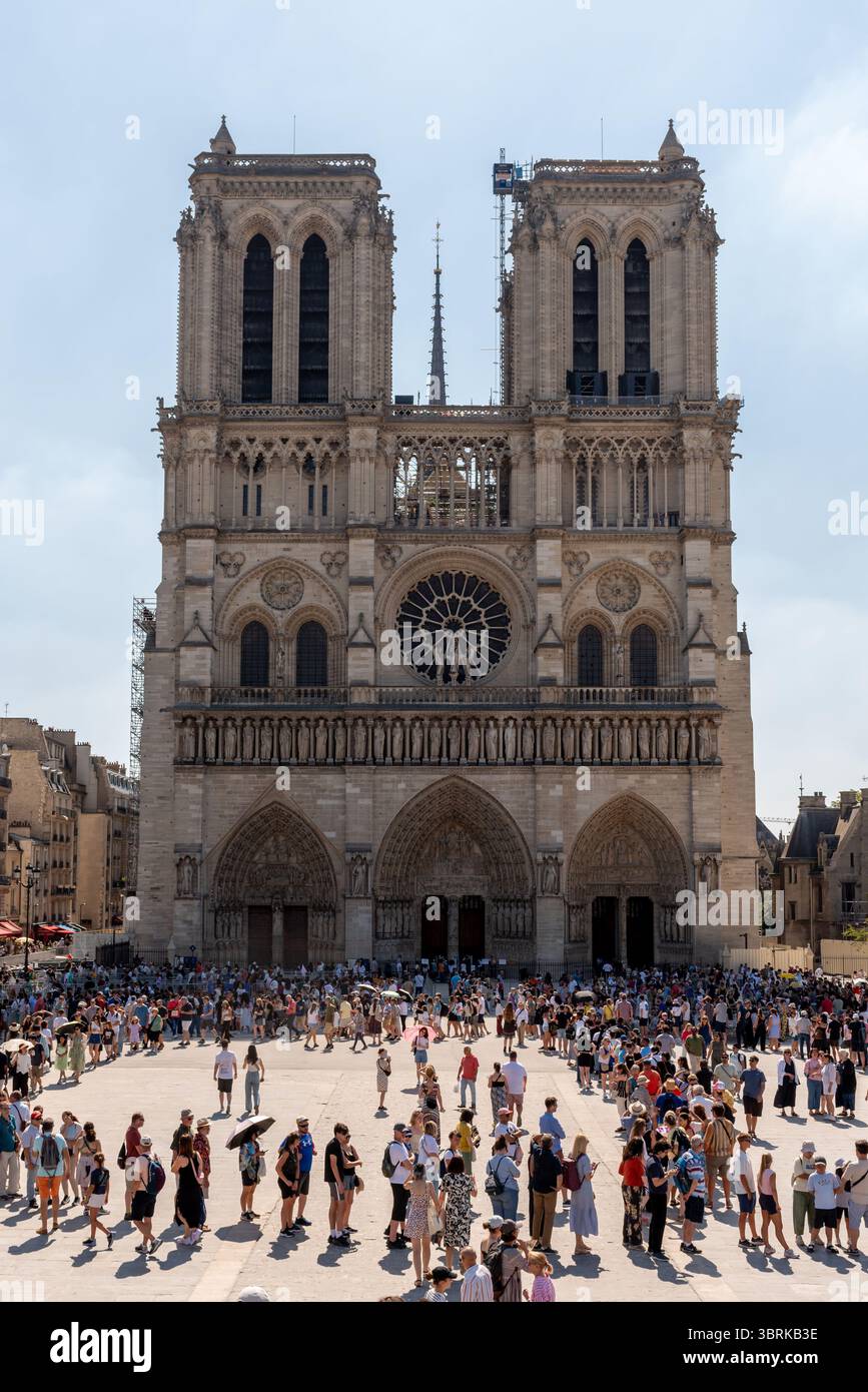 Gente che fa la fila nel caldo per entrare a Notre Dame in un giorno d'estate di sole. Notre Dame è ancora in fase di restauro nel 2025 Foto Stock