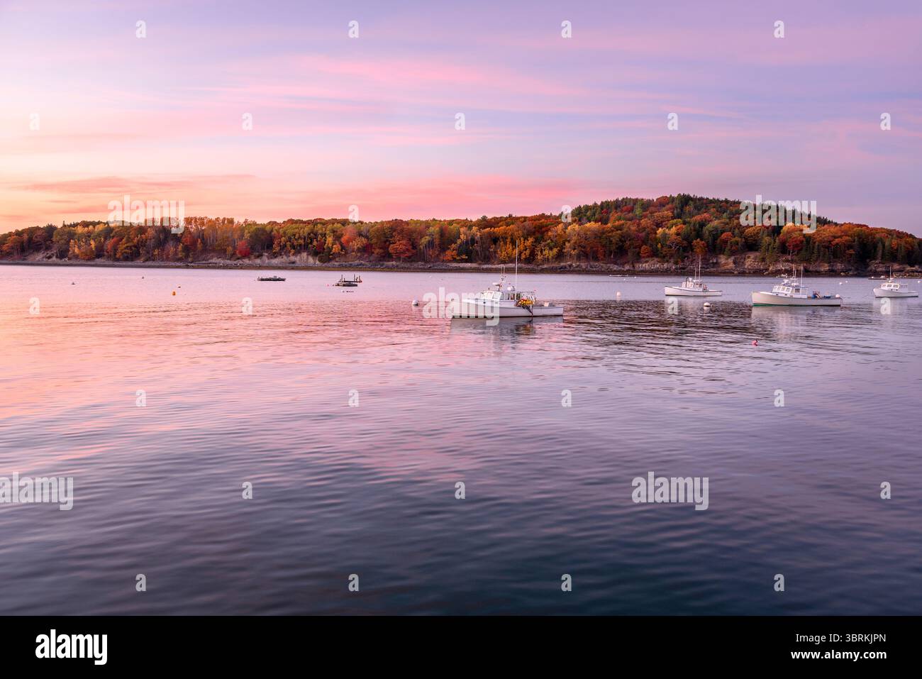 Barche da pesca in un porto sotto il cielo spettacolare al tramonto in autunno. Colori autunnali sullo sfondo. Foto Stock