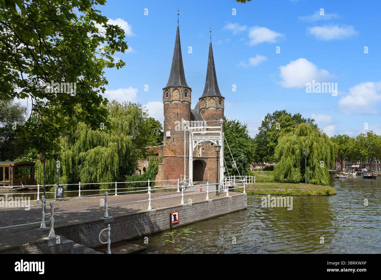 L'iconica Oostpoort (porta orientale) a Delft, un pittoresco monumento medievale con le sue guglie gemelle, il ponte levatoio e i canali circostanti. Foto Stock