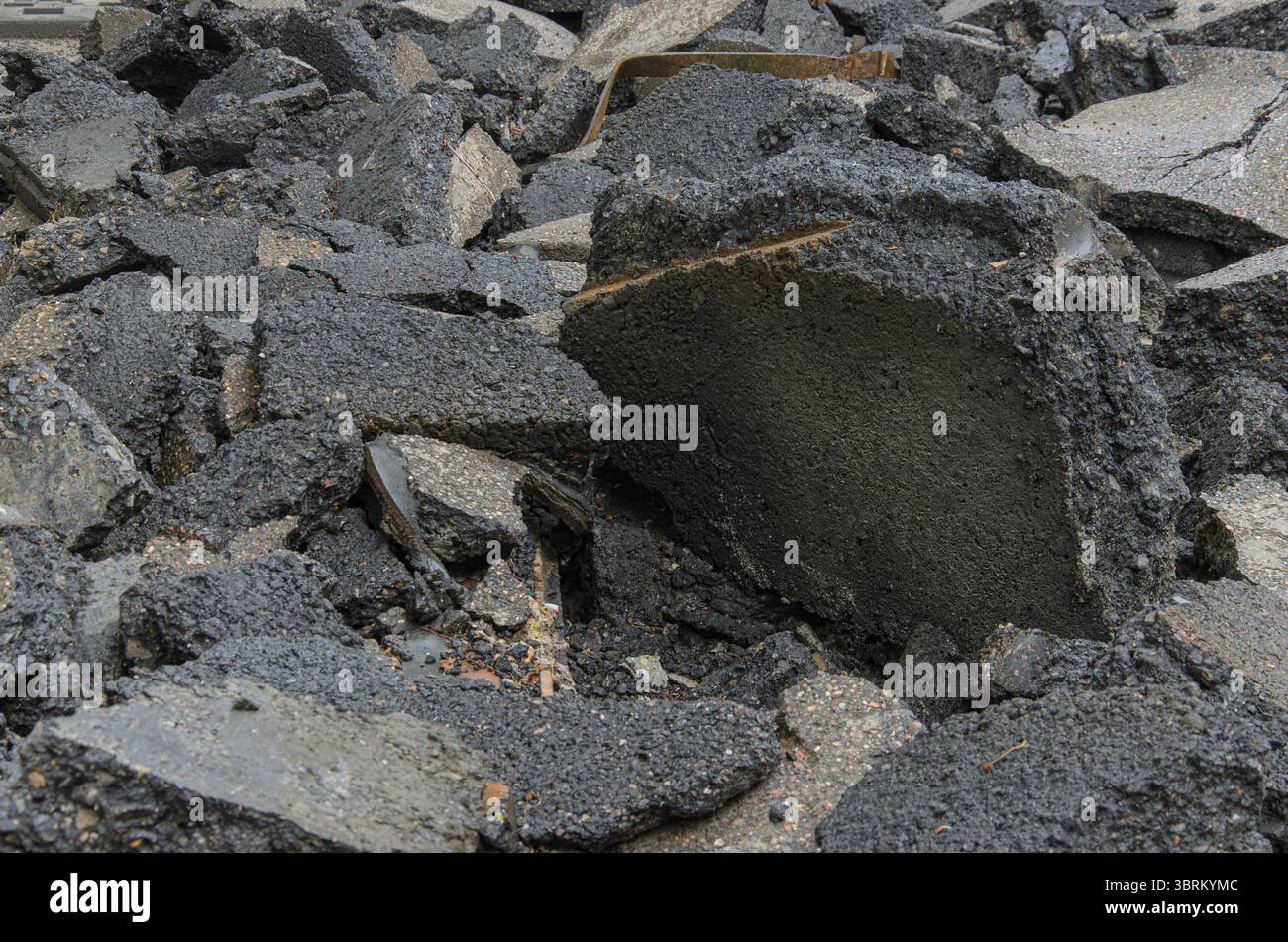 Fondo di accumulo di detriti su asfalto rotto. Foto Stock