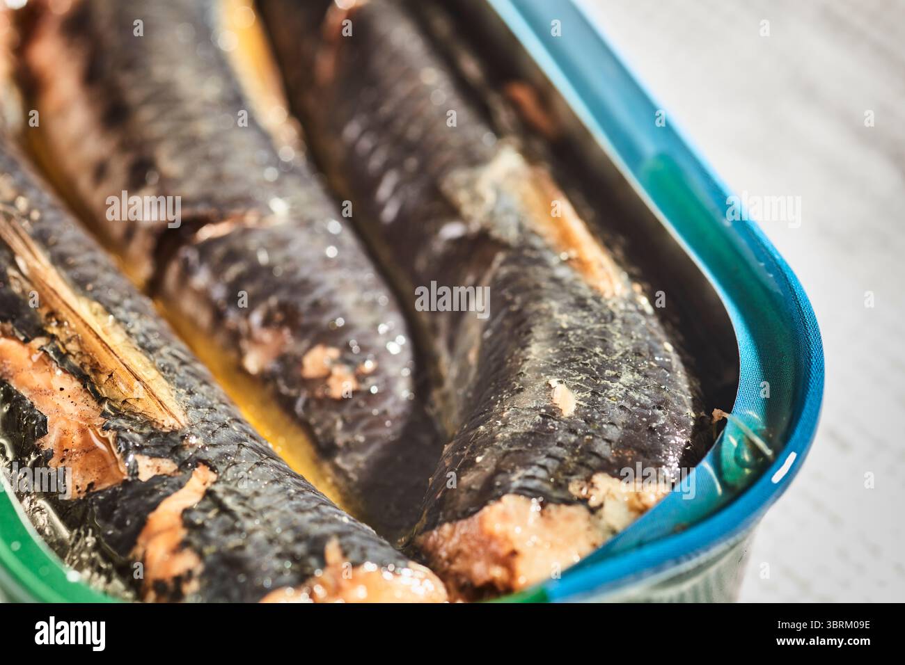 Un barattolo aperto (stagno) di sardine del Pacifico con la pelle sopra. Foto Stock