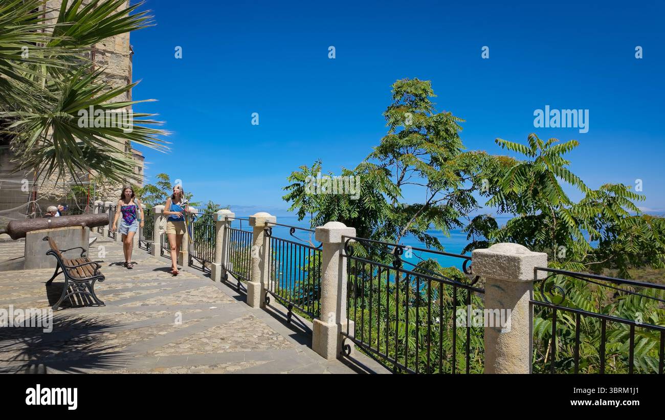TROPEA, ITALIA - 2 GIUGNO 2025 - due turisti che camminano su una terrazza panoramica affacciata sul Mar Tirreno a Tropea, Calabria, Italia meridionale Foto Stock