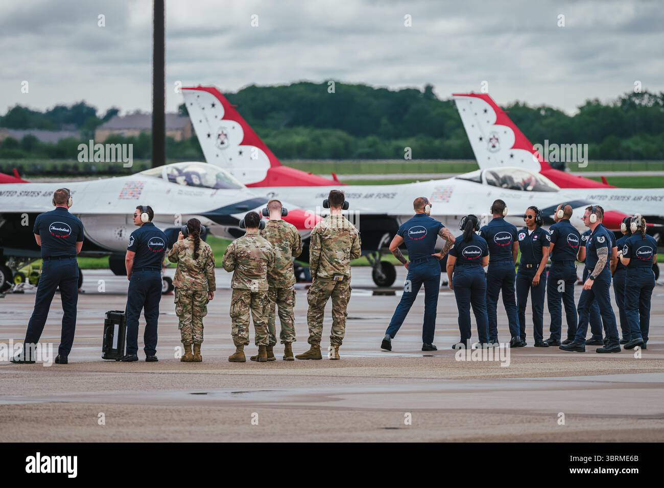 L'equipaggio di terra e di supporto dell'USAF Thunderbirds è in formazione durante le operazioni pre-volo presso la McGuire AFB, 16 maggio 2025, con i jet F-16 in background. Foto Stock
