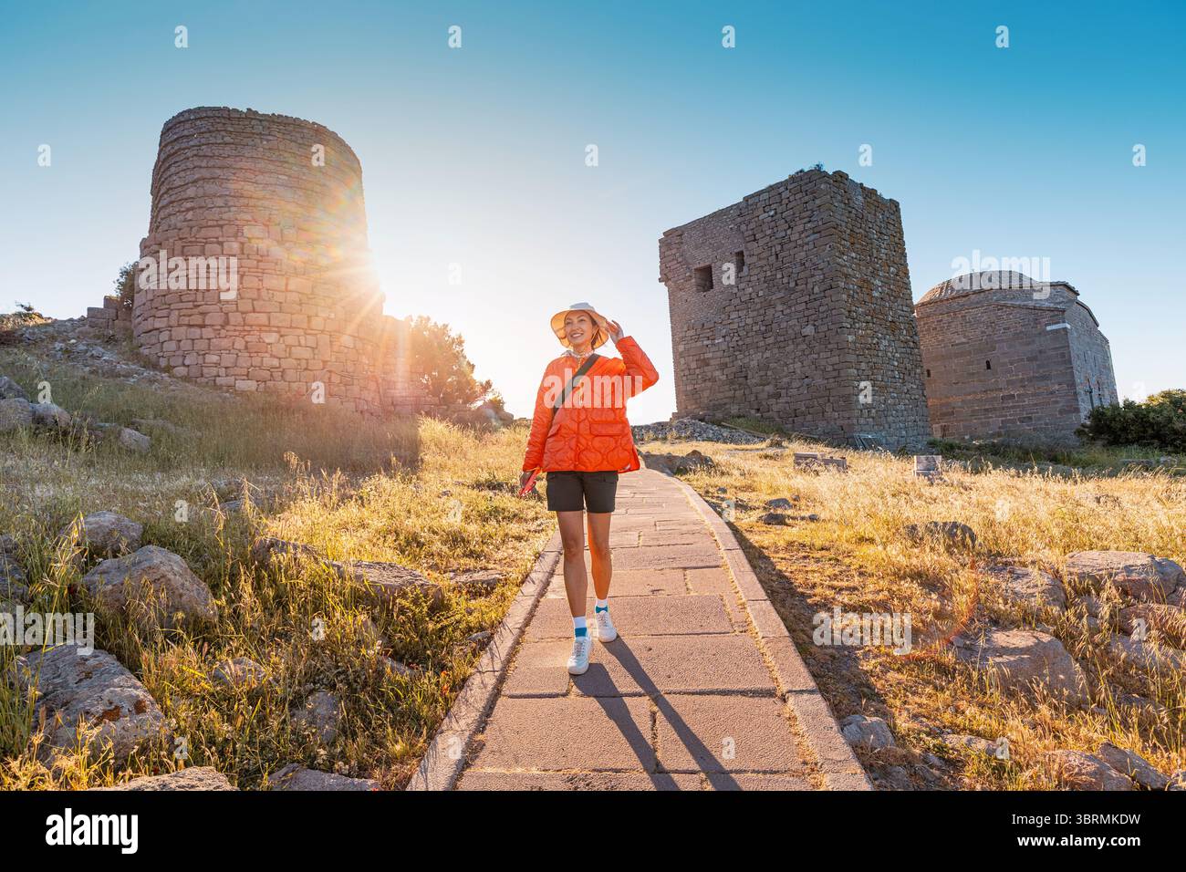 Turista che esplora le rovine di Assos, un'antica città greca situata nella moderna Behramkale, Turchia Foto Stock