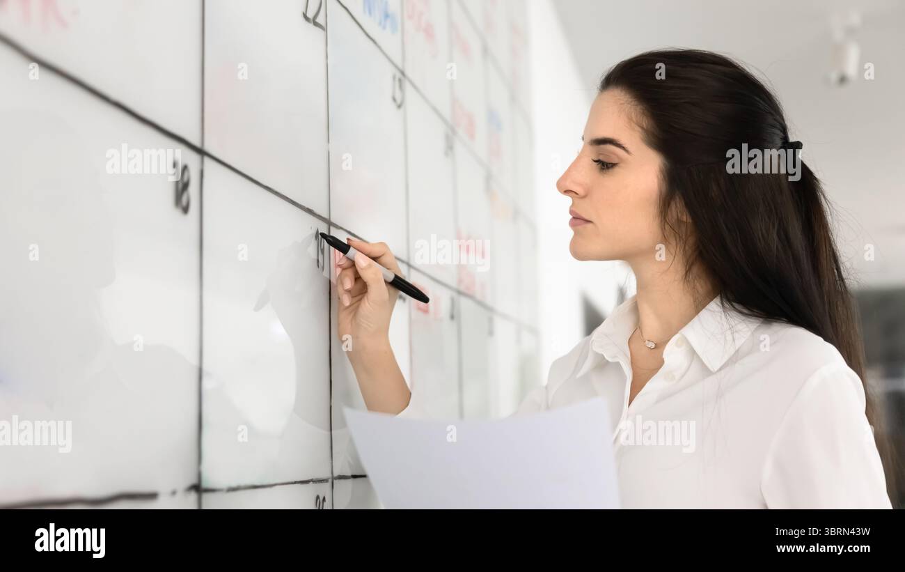 Vista ravvicinata, manager donna che scrive il business plan utilizzando la lavagna Foto Stock