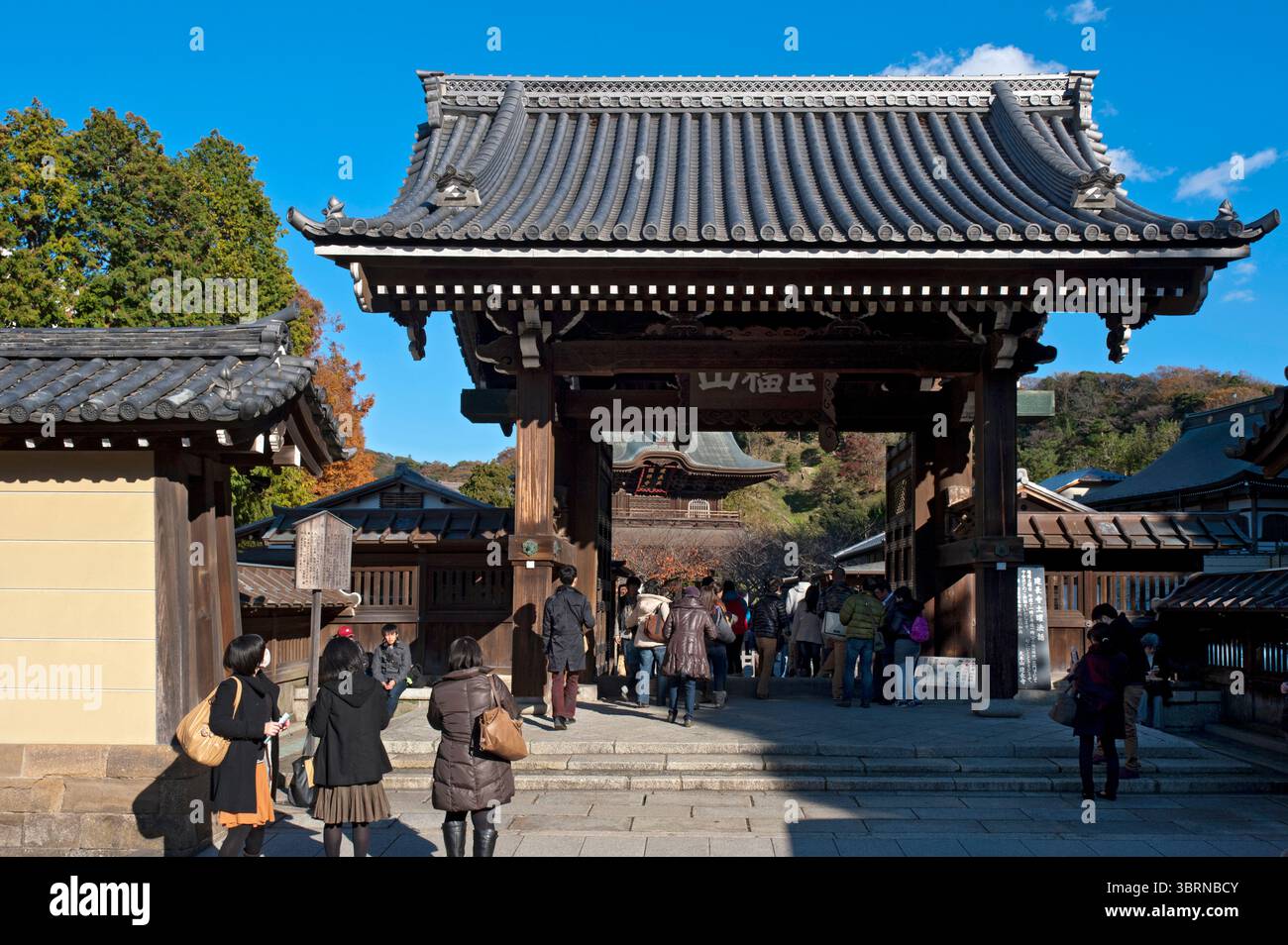 I visitatori passano attraverso la porta principale Kenchoji (建長寺) Somon (総門) del tempio buddista Zen a Kamakura, Kanagawa, Giappone. Foto Stock