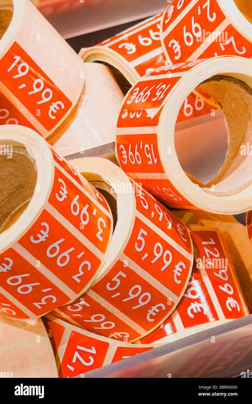 Rotoli di adesivi rossi scontati nel negozio di moda. Cartellini promozionali per la vendita di abbigliamento Foto Stock
