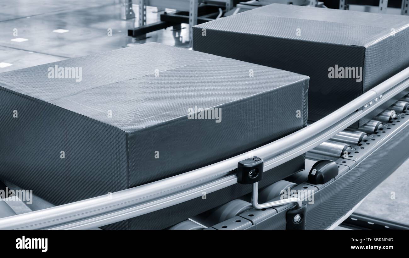 Scatole di cartone sul nastro trasportatore del moderno centro logistico di distribuzione, sfondo del concetto logistico di consegna tono blu Foto Stock