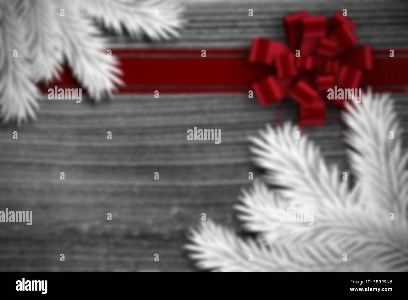 La confezione regalo per le feste dal design piatto mostra un fiocco in raso rosso con rami di pino bianco su tavole grigie Foto Stock