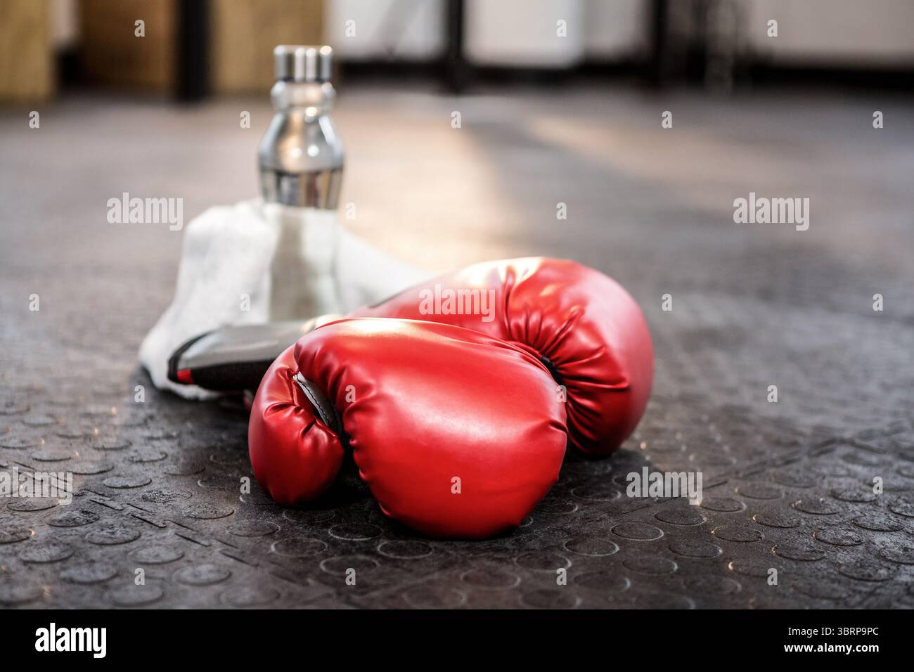 Guanti da boxe con bottiglia sul pavimento Foto Stock