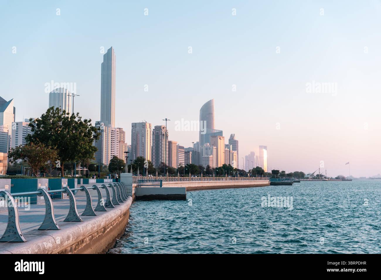 Vista della Corniche di Abu Dhabi al tramonto, fotografia cinematografica dello skyline del porticciolo di Abu Dhabi con il mare Foto Stock