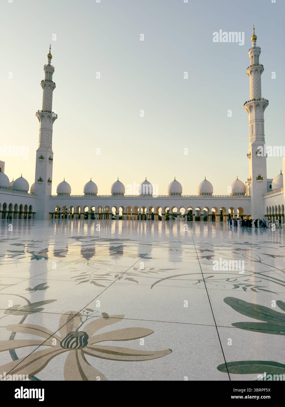 Vista interna della grande moschea di Abu Dhabi al tramonto, pavimento con intarsi in marmo, archi in pietra, interni in marmo bianco Foto Stock