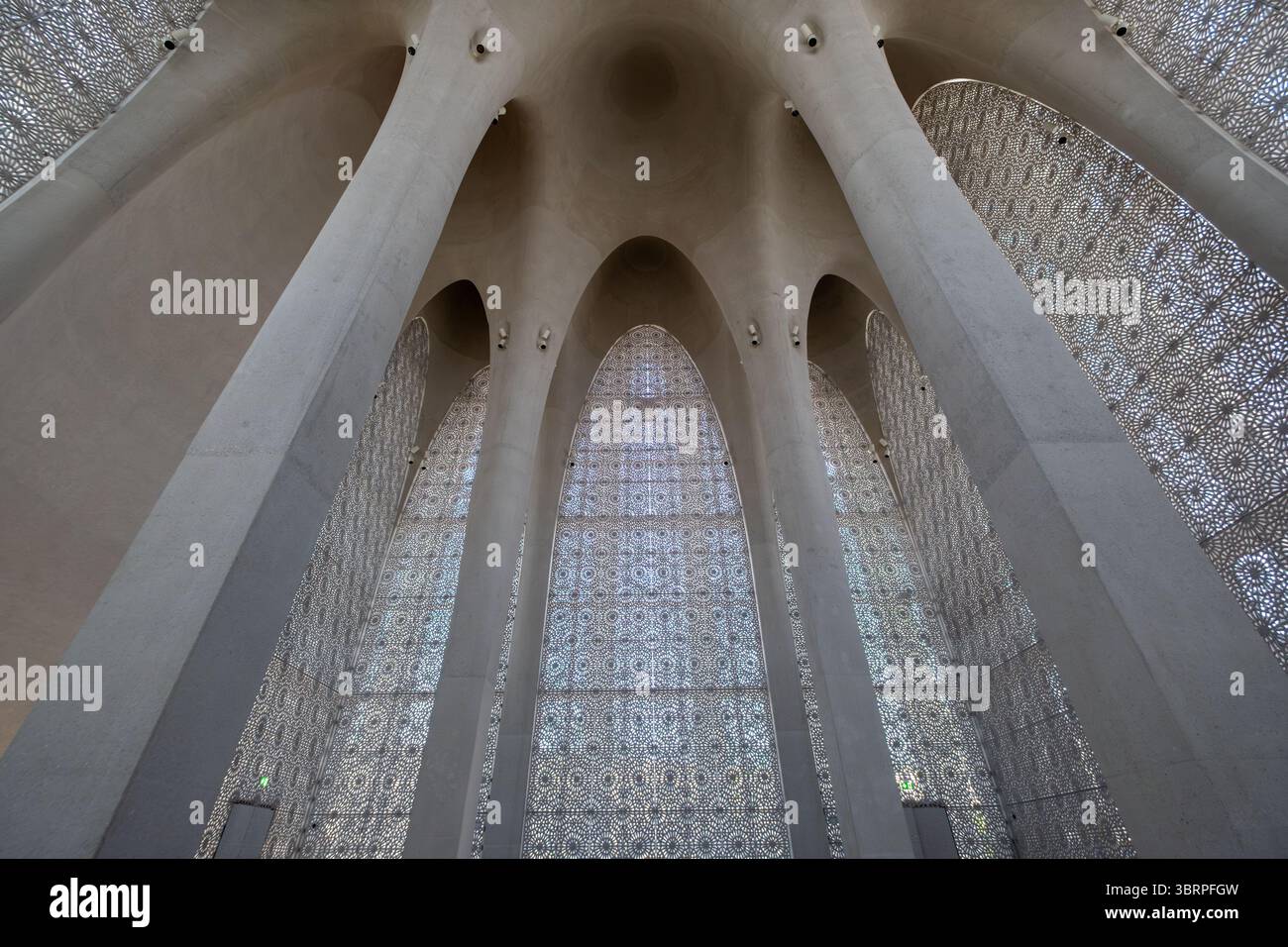 Interni architettonici con colonne ad arco torreggianti e intricate pareti a motivi geometrici, che creano un'atmosfera spaziosa e simile a una cattedrale. Foto Stock