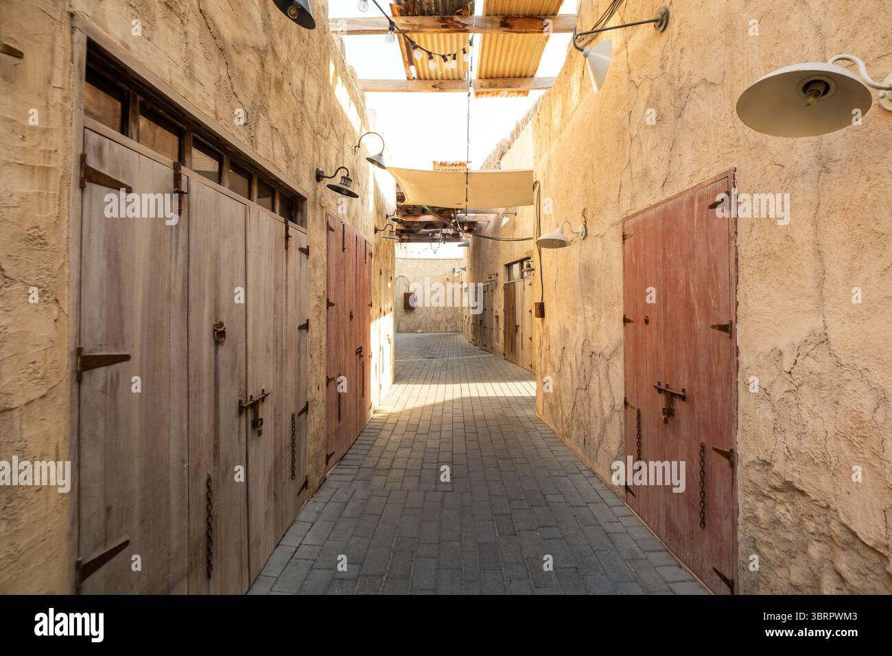 Elegante e stretta strada della città vecchia con vecchie case, antiche porte e finestre in legno, luce del sole che splende attraverso il tetto, architetto prospettico cinematografico Foto Stock