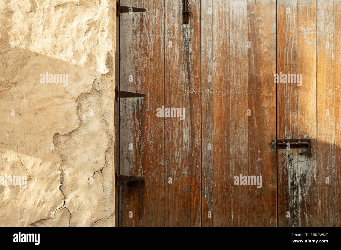 vecchia porta in legno su pareti di fango con effetto calce, vecchie case cittadine con porte e finestre colorate Foto Stock