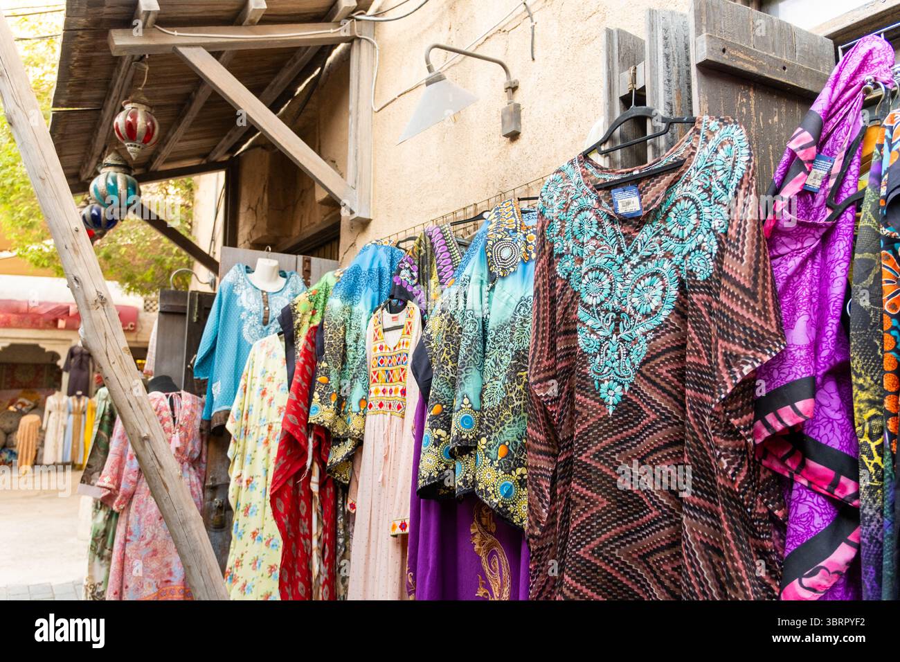 Al seef Market mostra con abaya e kaftani colorati, Dubai Street Market con edifici storici e fascino mediorientale Foto Stock
