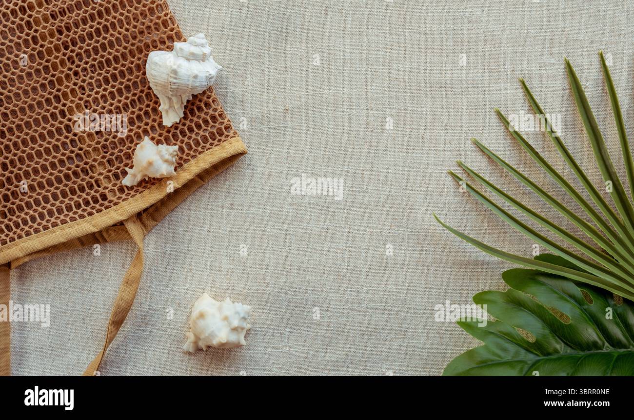 piatto ispirato alla spiaggia con conchiglie, borsa da spiaggia e foglie tropicali, spazio vuoto per testo e grafica Foto Stock