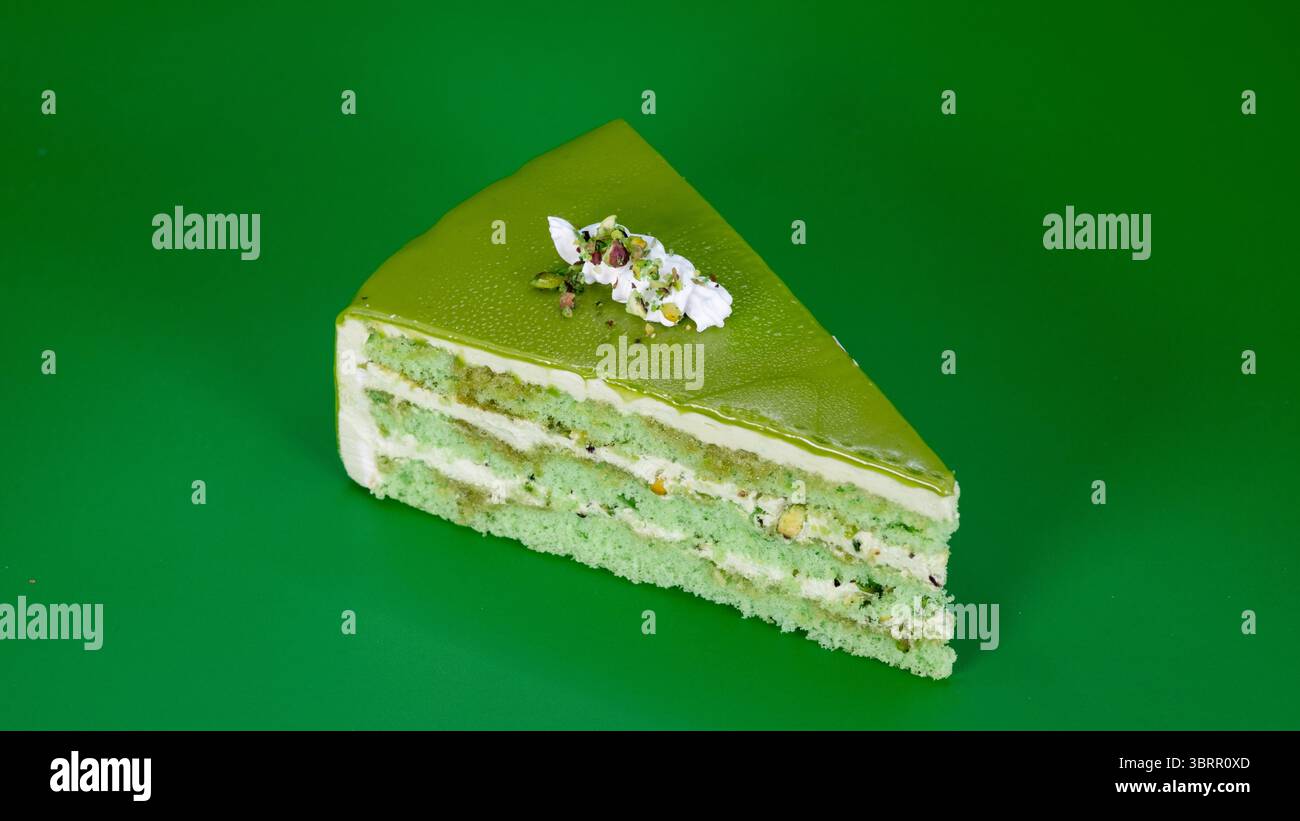 Torta a strati di pistacchio con glassa di panna montata e condita con nocciole di pistacchio fresche isolate sullo sfondo, torta al cioccolato virale di Dubai Foto Stock